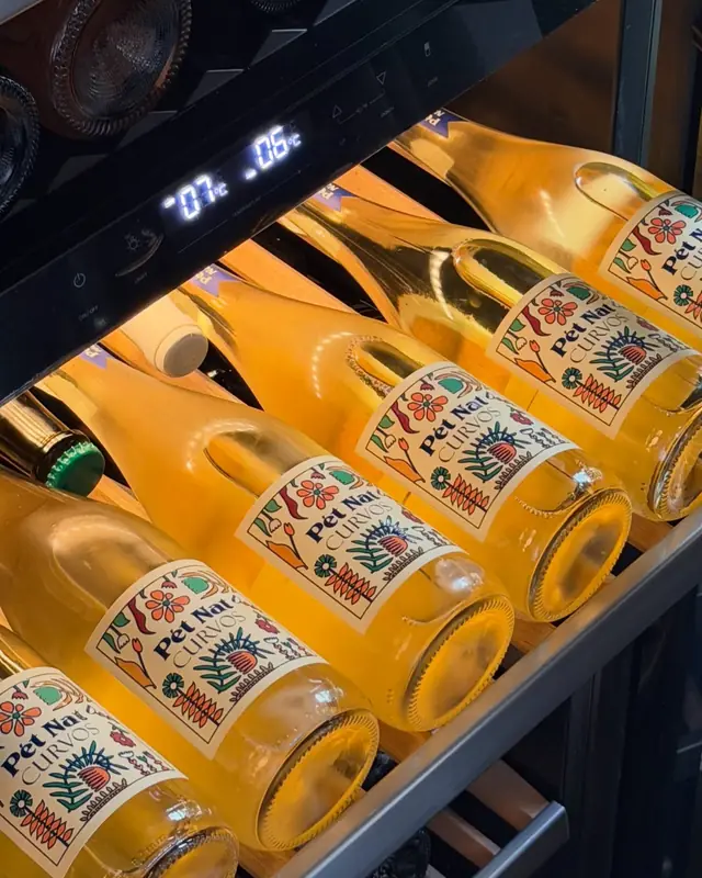 Butelki wina Pet Nat w podświetlonej chłodziarce